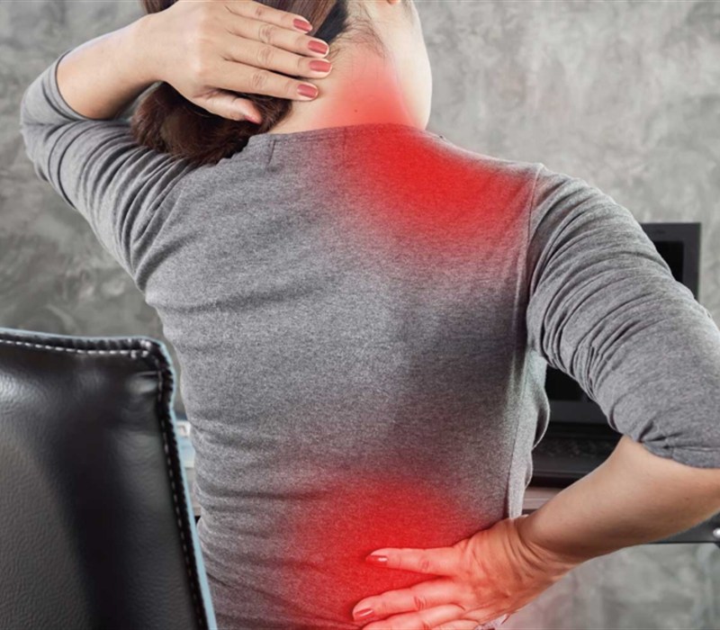 Mujer con dolor de cuello y espalda baja por tensión muscular crónica